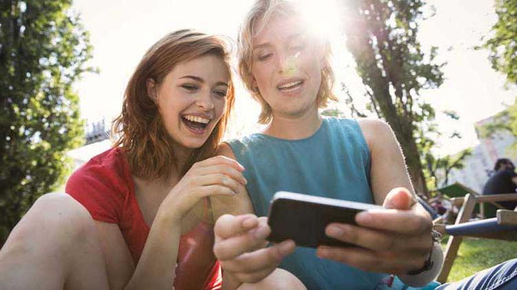 Phone application safety is important for these two ladies looking at a smartphone.