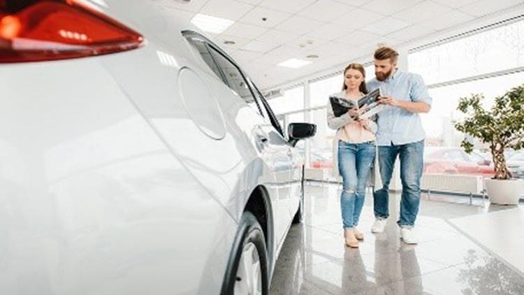 Couple at a dealership buying a car and deciding on their car loan term.